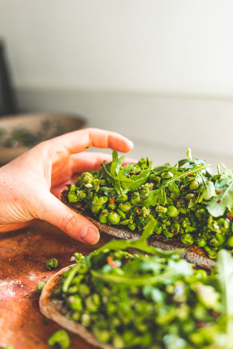 picking up a slice of Peas on Toast with Herbs & Lemon - Georgie Eats