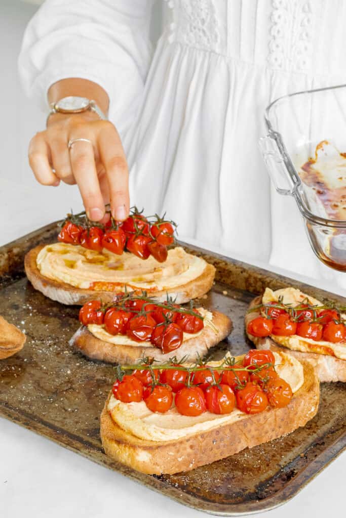 Layering the balsamic tomatoes on top of the sourdough toast.