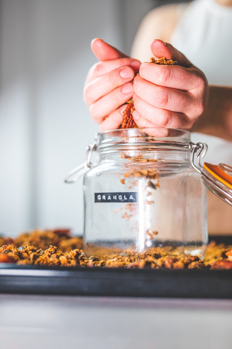 Putting the Maple Sea Salt Granola into a jar - Georgie Eats