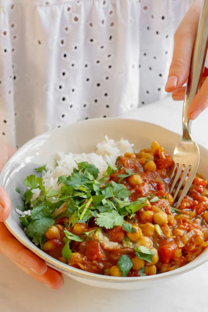Holding a bowl of Quick Chickpea Curry - Vegan, GF & Healthy! Georgie Eats.