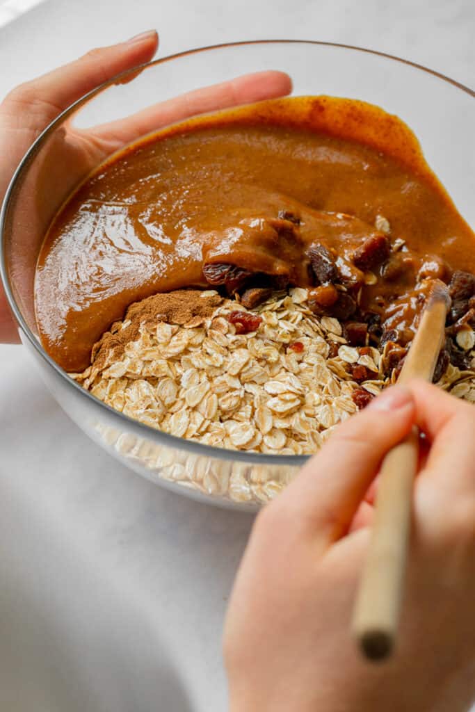 Mixing together the wet and dry ingredients in a bowl.