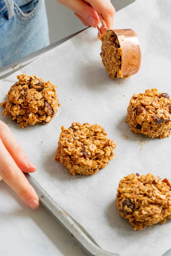 Portioning the no-bake cookies out onto a baking sheet.