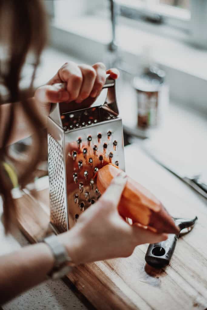 Grating a sweet potato.