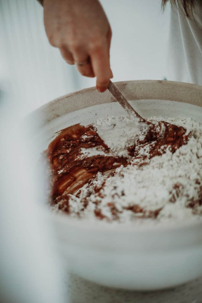 Mixing flour into the wet ingredients.