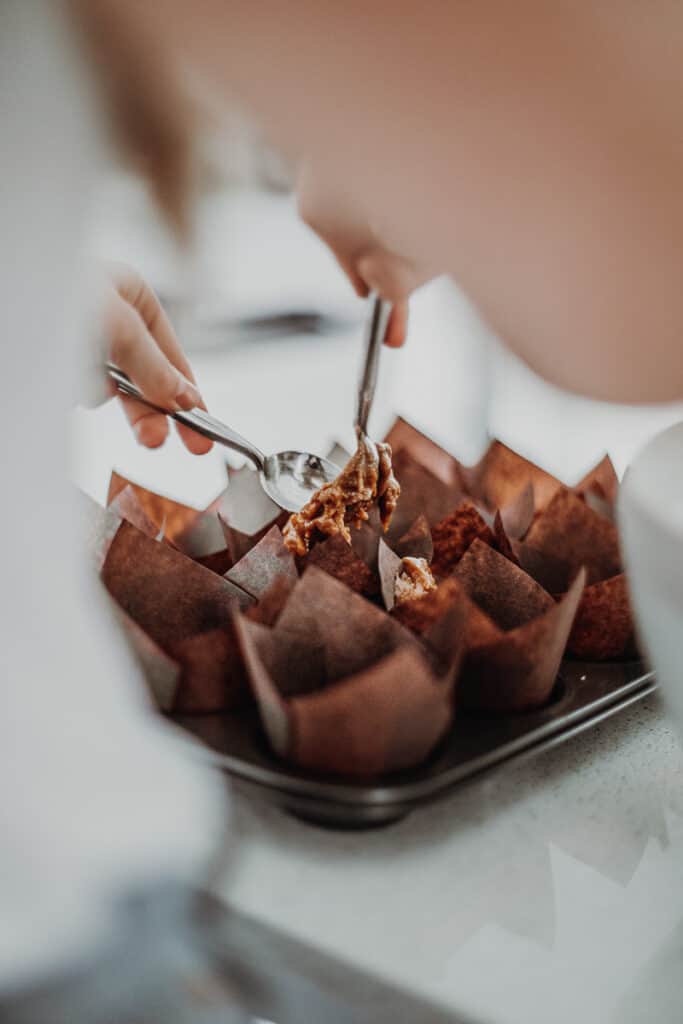 Filling the muffin cases with mixture.
