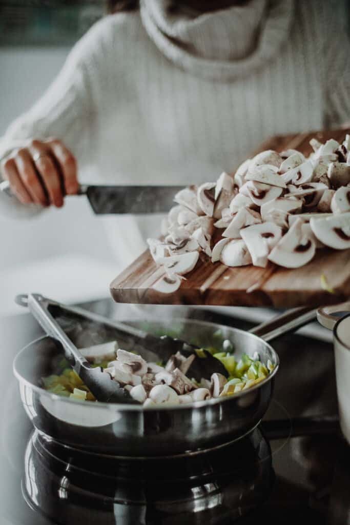 adding the mushrooms into the saucepan