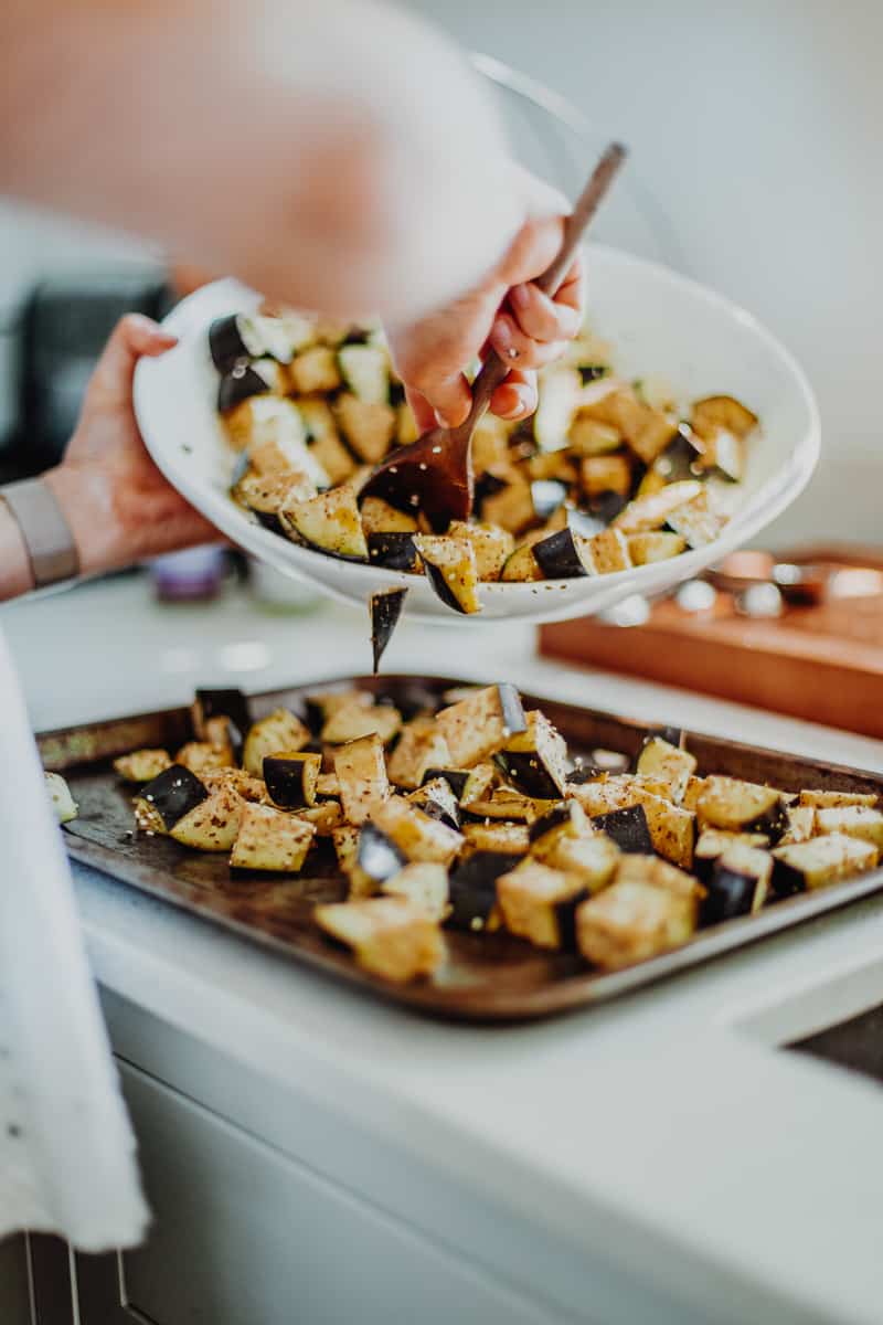 Pouring the aubergine out onto a baking tray