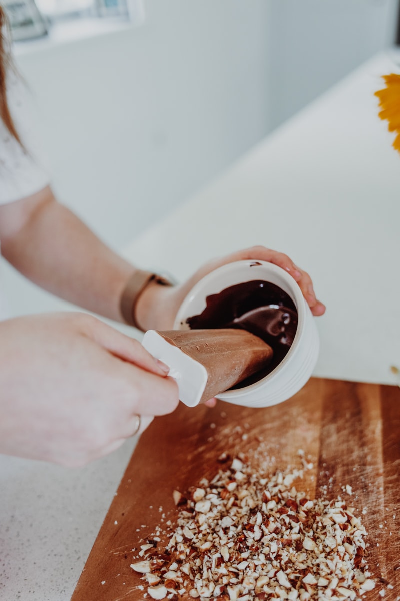 covering an ice lolly in dark chocolate