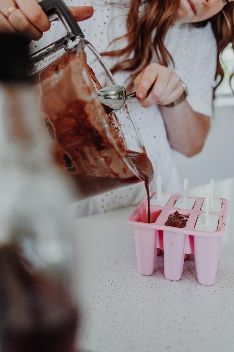 pouring the chocolate fudge ice lolly mix into a mould