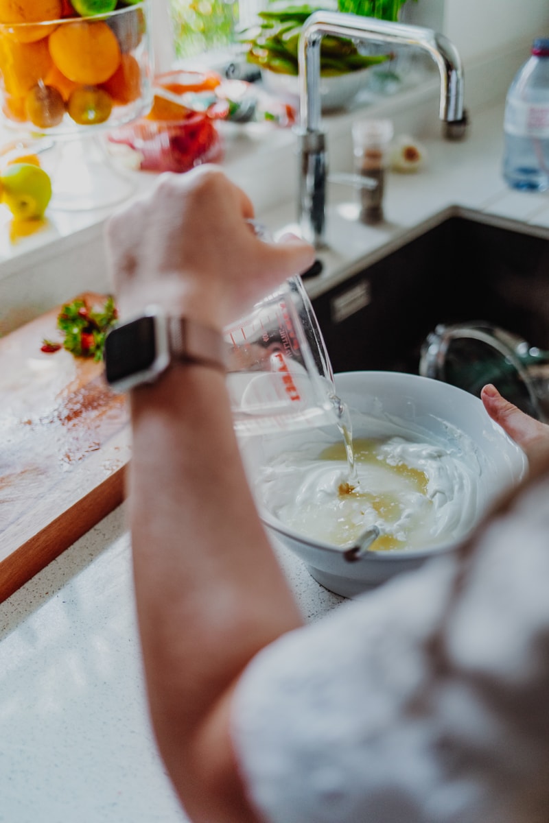 pouring the elderflower cordial into the yoghurt