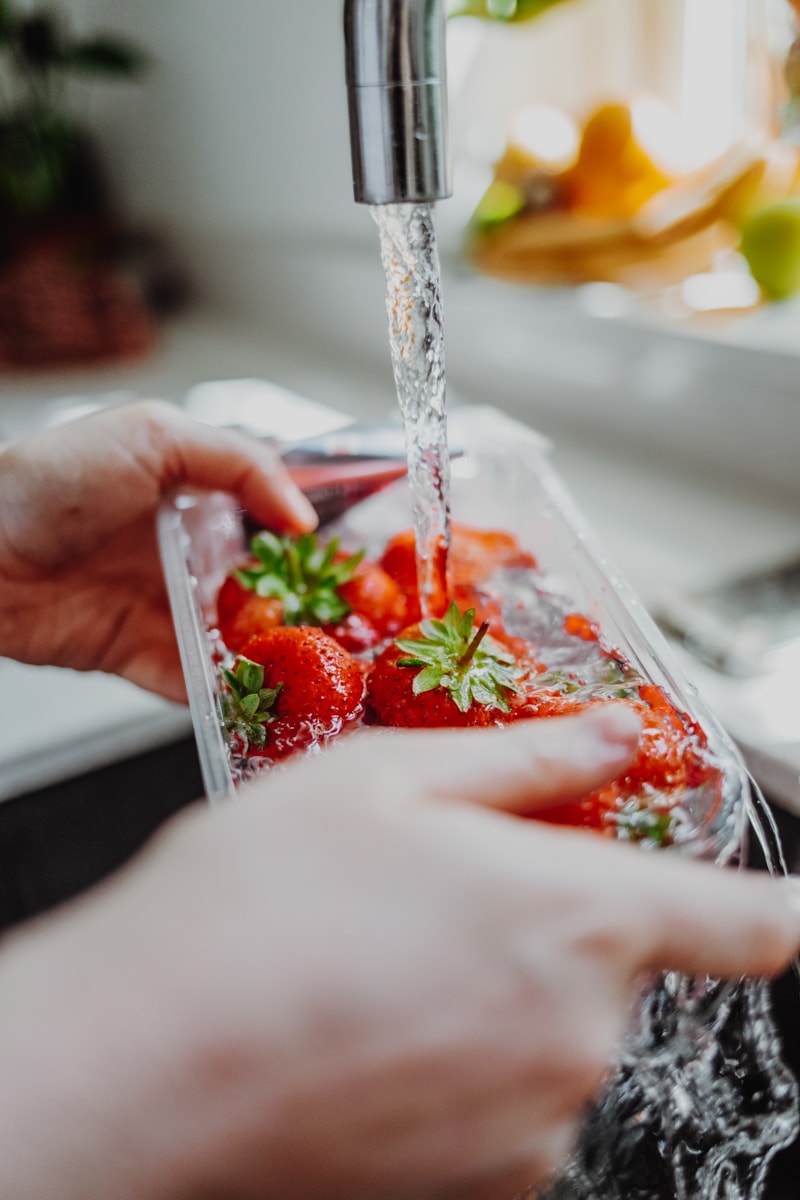 washing a punnet of strawberries