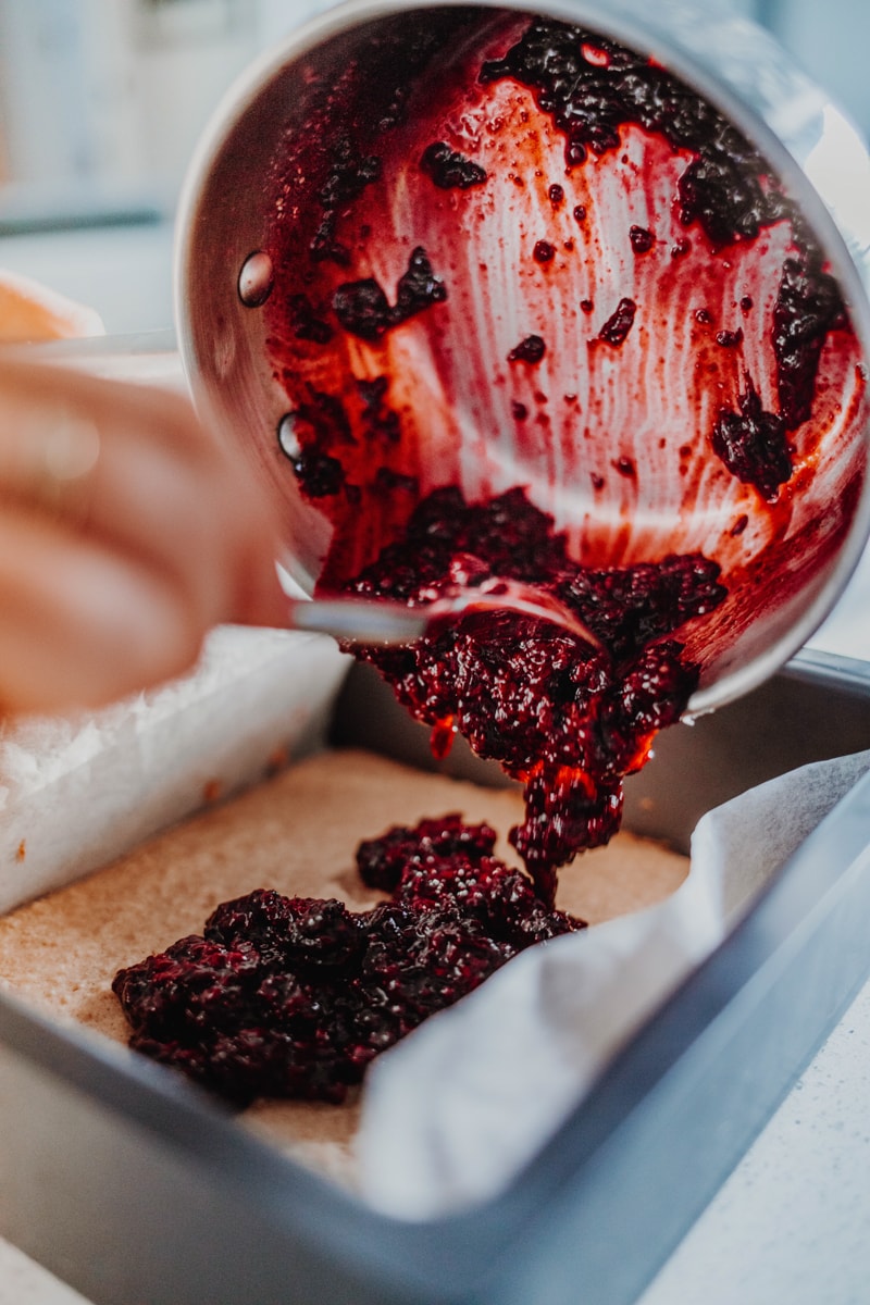 Adding the blackberry chia jam over the partially baked blondie mix