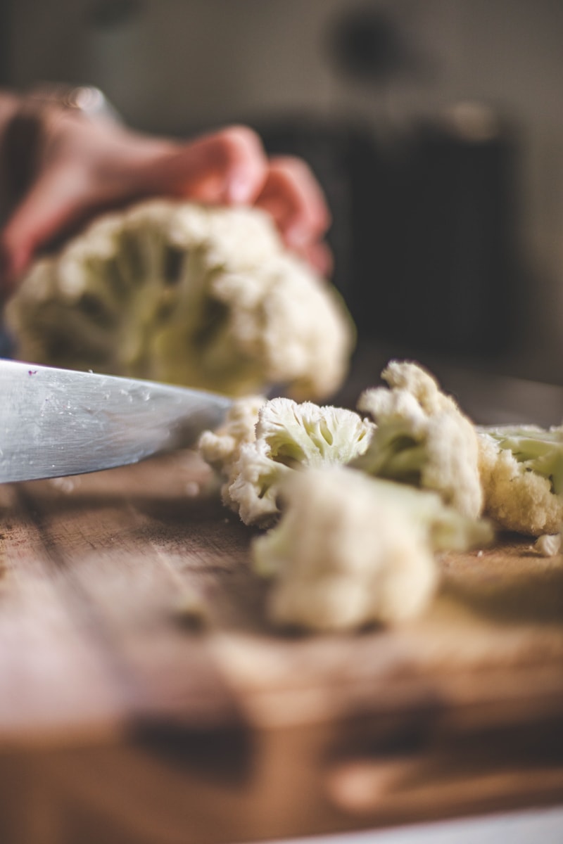chopping cauliflower on a board