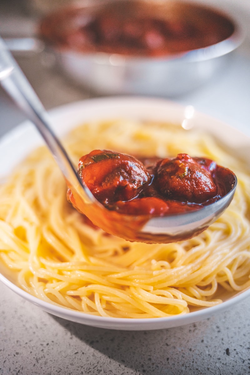 Serving the Vegan Meatballs onto spaghetti