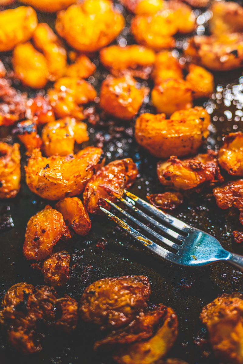 Smashed Harissa Potatoes on a tray - Georgie Eats
