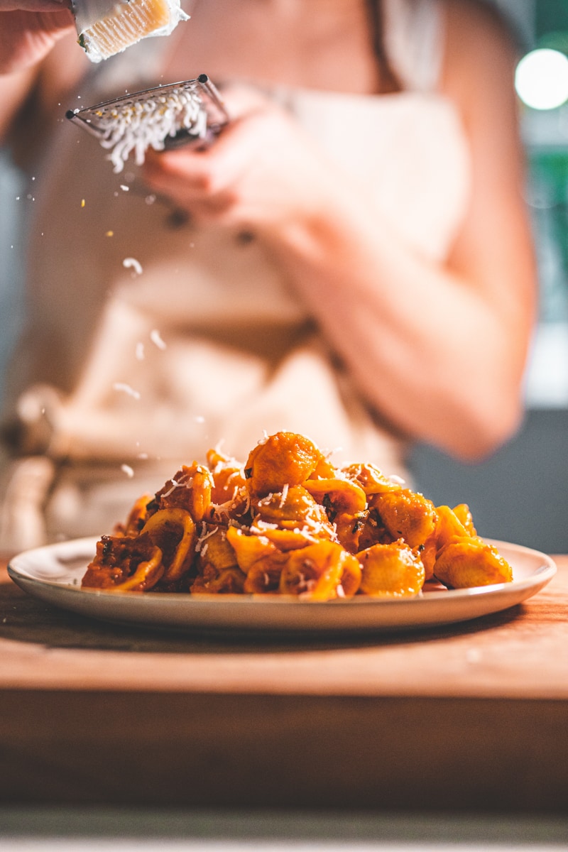 Grating parmesan on Roasted Red Pepper Pasta - Georgie Eats