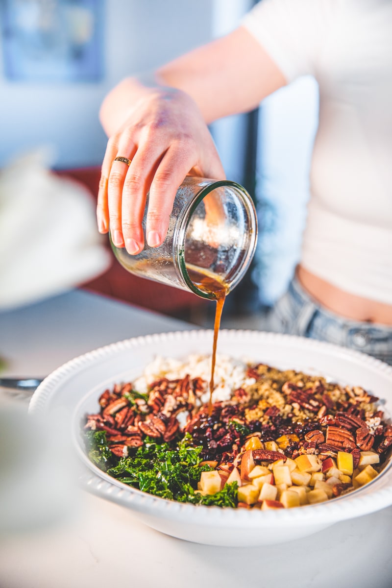 Pouring dressing over Kale & Apple Salad - Georgie Eats