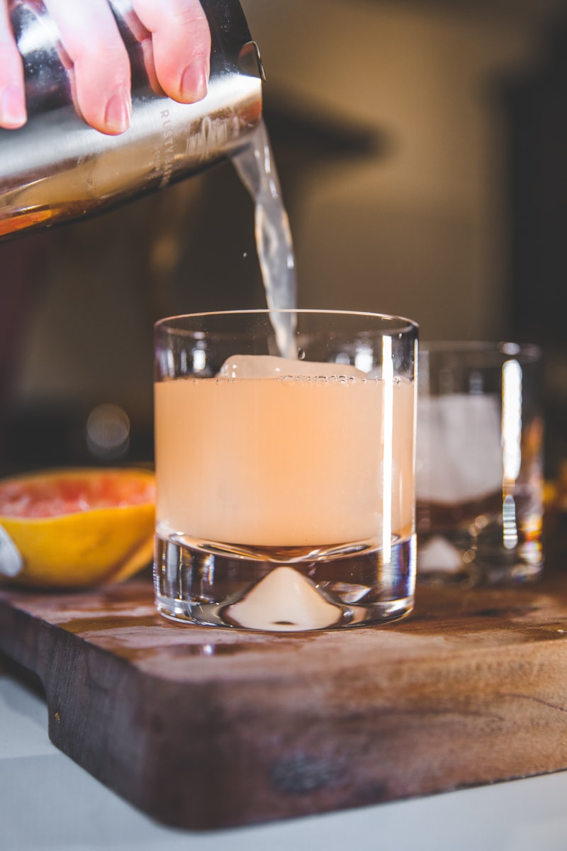 Pouring the Greyhound Cocktail with Rosemary - Georgie Eats