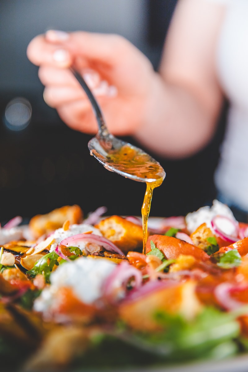 Drizzling Tomato Dressing on Peach Panzanella Salad - Georgie Eats