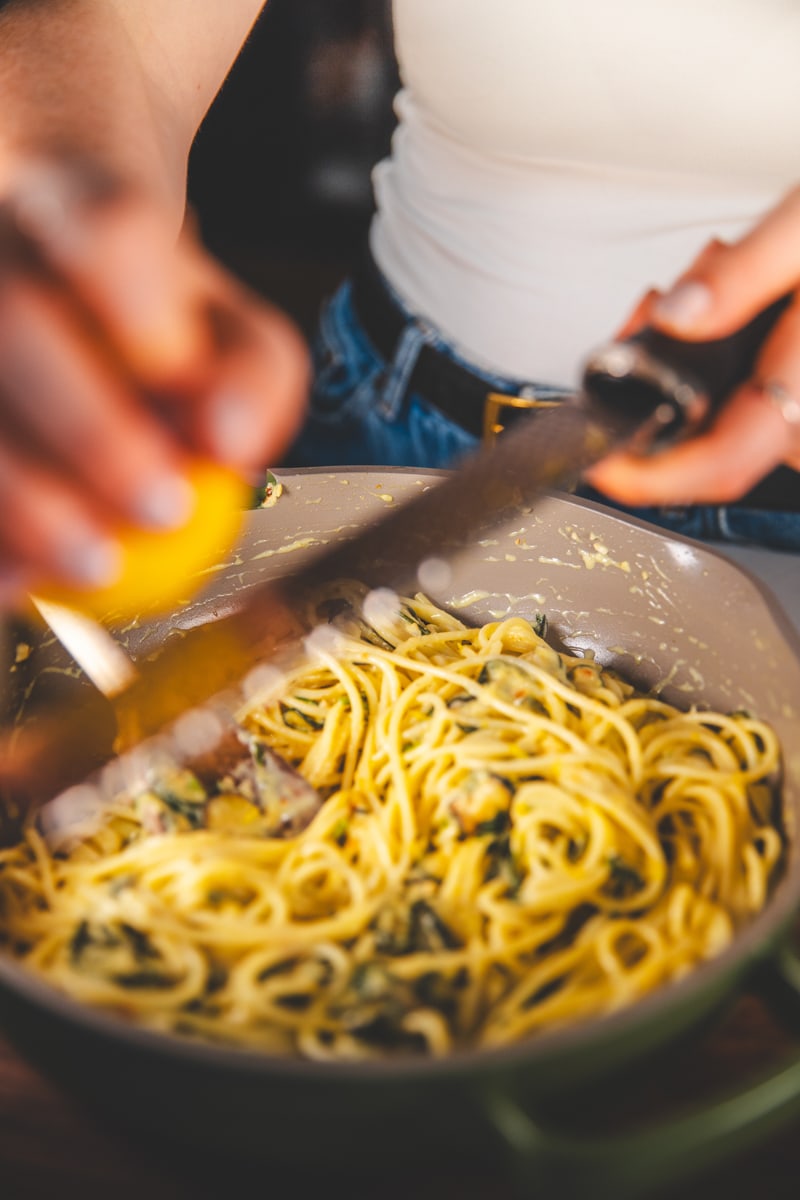 Grating lemon zest over Slow-Cooked Courgette Pasta - Georgie Eats