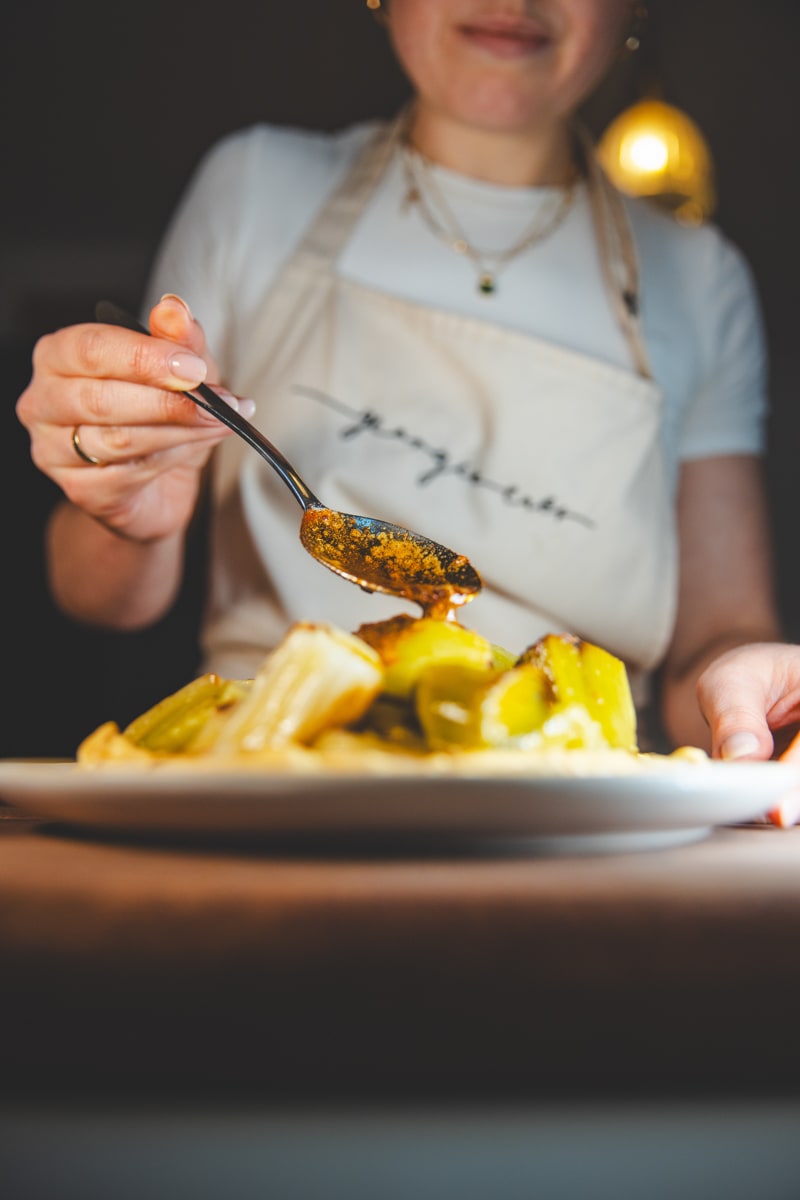 Spooning the tempering butter over Braised Leeks with Lime Pickle Yoghurt - Georgie Eats