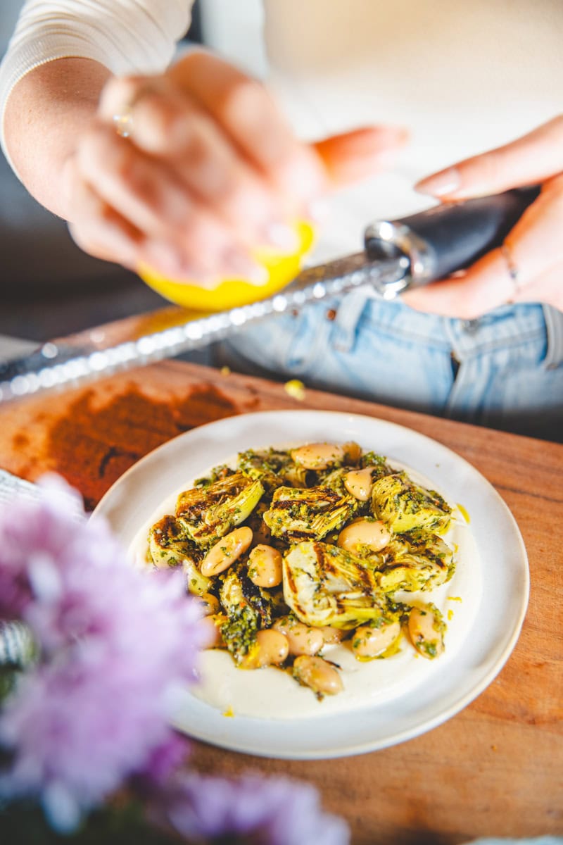zesting lemon over Grilled Artichoke & Butter Bean Salad with Gremolata Dressing - Georgie Eats