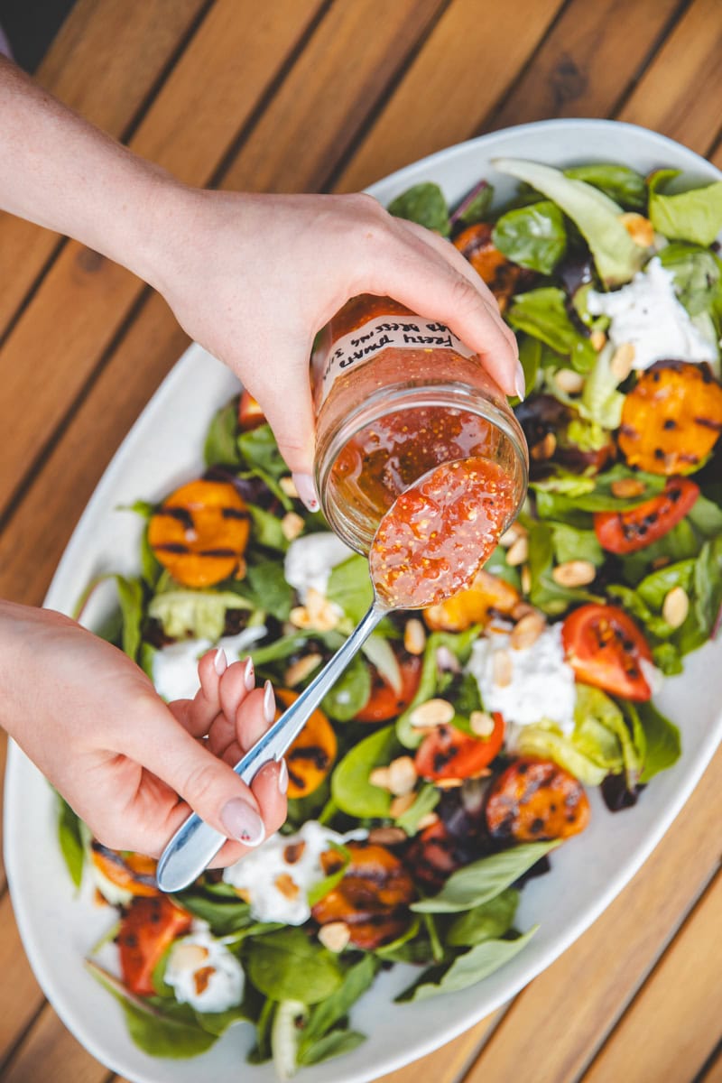 Pouring dressing on Griddled Apricot Salad - Georgie Eats