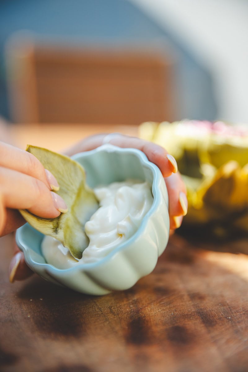 dipping the artichoke petals in sauce - Georgie Eats