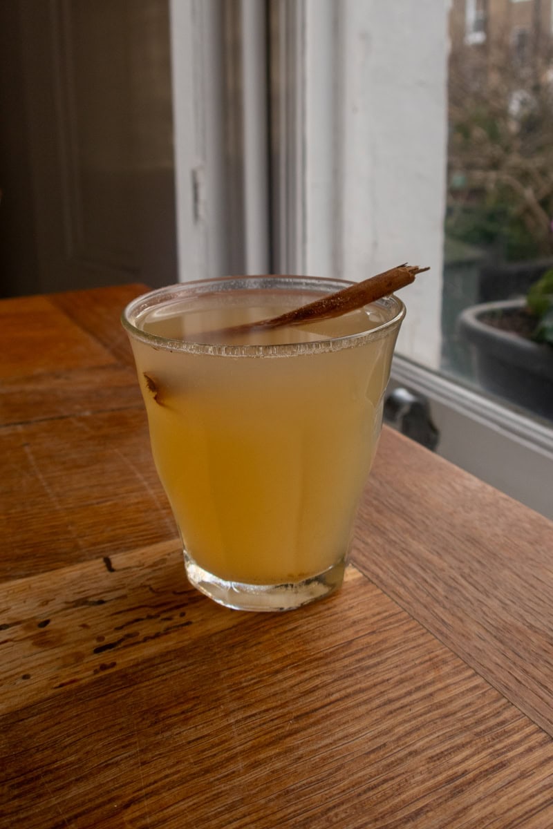 A warm glass of non-alcoholic apple toddy, garnished with a cinnamon stick - Georgie Mullen